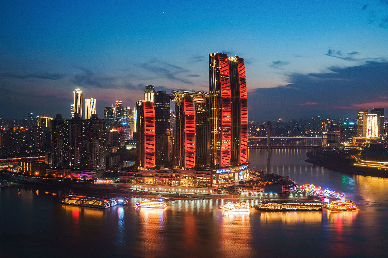 Paisaje urbano de Chongqing de noche, una ciudad futurista donde la arquitectura moderna, los ríos y los cruceros crean una experiencia inolvidable.