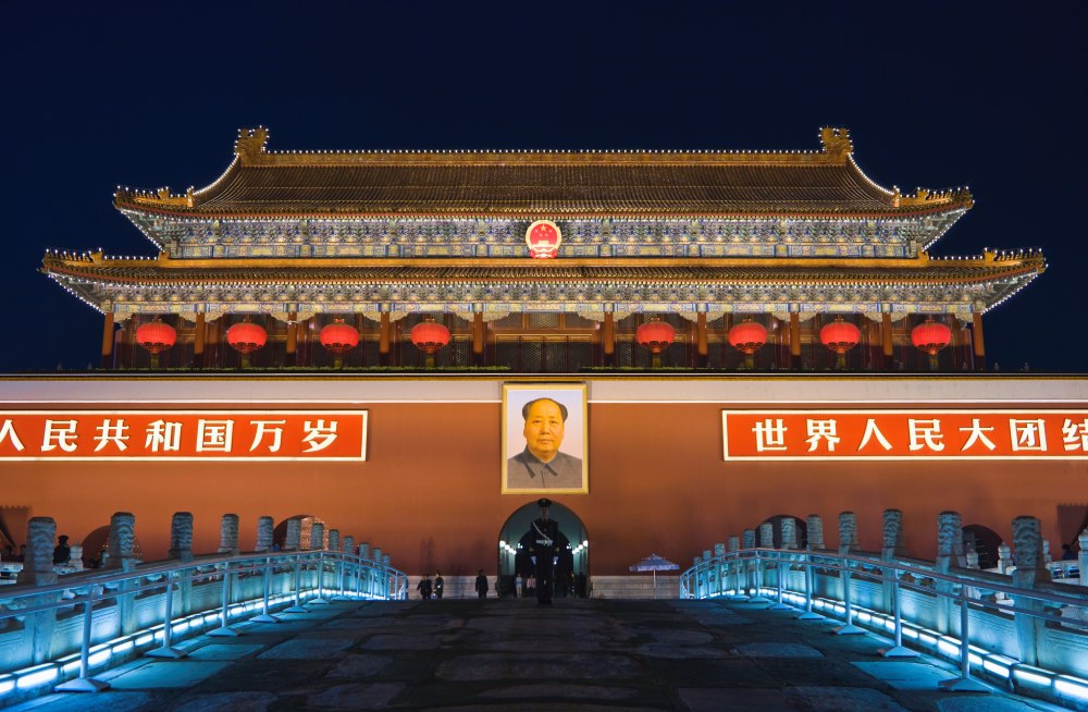 Puerta de Tiananmén en Pekín iluminada por la noche, uno de los lugares imprescindibles para visitar en China por su importancia histórica y cultural.